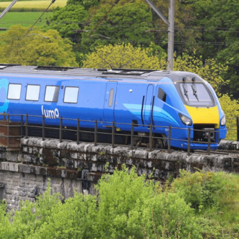 Lumo train crossing a stone railway viaduct