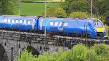 Lumo train crossing a stone railway viaduct