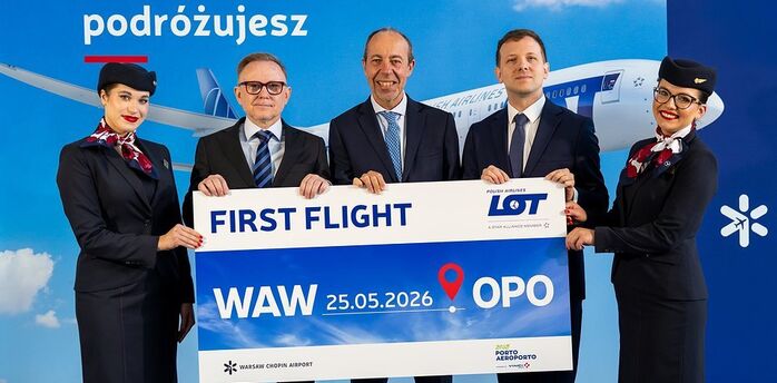 LOT Polish Airlines crew holding a Warsaw to Porto first flight sign