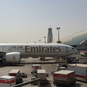 Emirates aircraft parked at Dubai International Airport beside the terminal