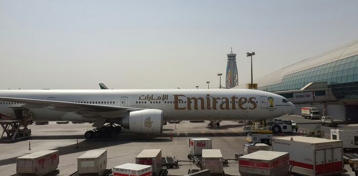 Emirates aircraft parked at Dubai International Airport beside the terminal