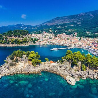 Coastal town in Greece with turquoise water, hills and a small harbour