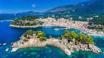 Coastal town in Greece with turquoise water, hills and a small harbour