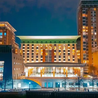Canary Riverside Plaza hotel building lit up at night beside the water