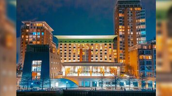 Canary Riverside Plaza hotel building lit up at night beside the water
