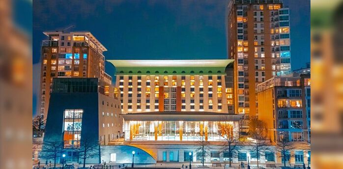 Canary Riverside Plaza hotel building lit up at night beside the water