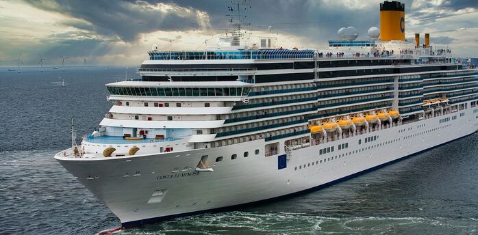 Costa cruise ship sailing at sea under a cloudy sky