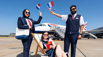 British Airways Cityflyer staff holding French flags beside an aircraft at London City Airport