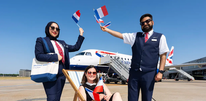 British Airways Cityflyer staff holding French flags beside an aircraft at London City Airport