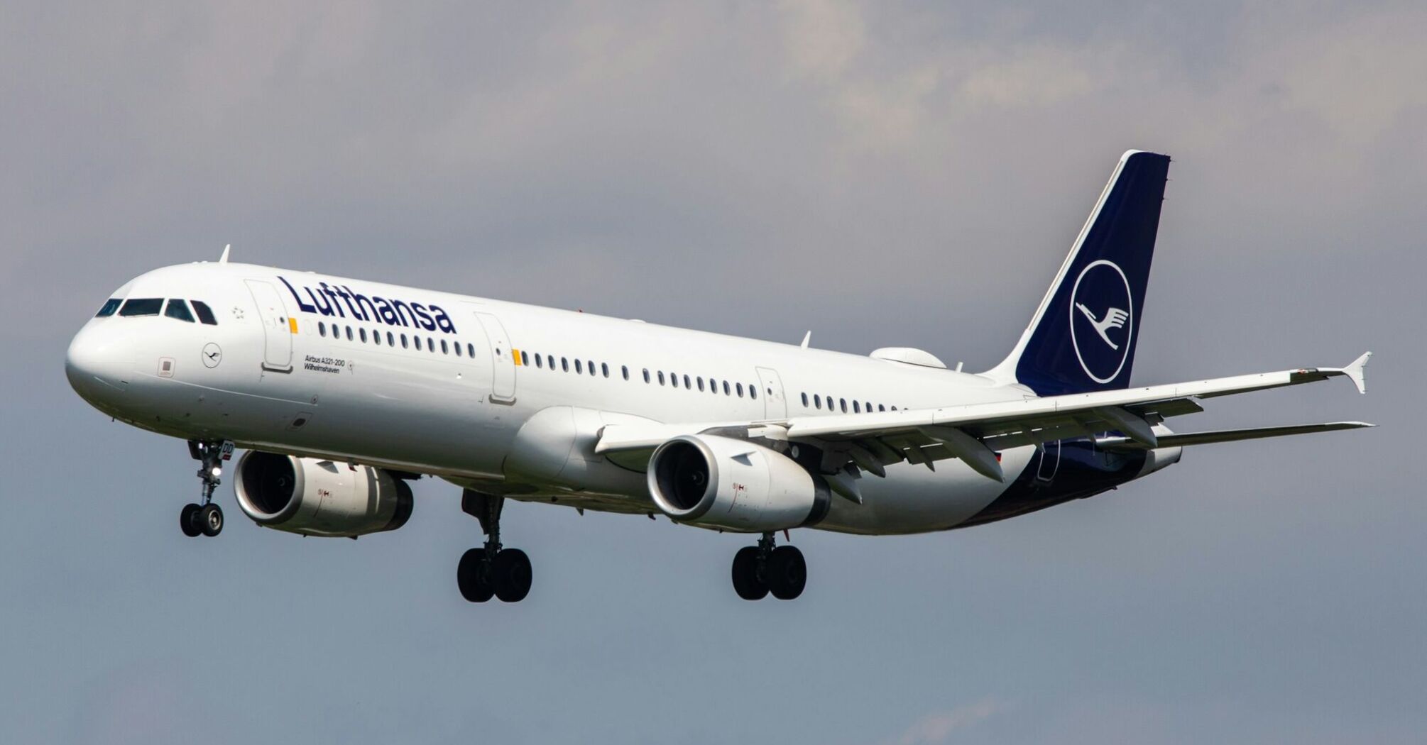 Lufthansa aircraft landing against a cloudy sky