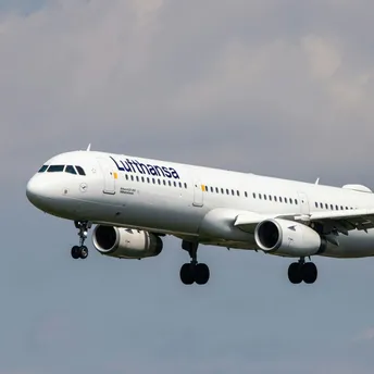 Lufthansa aircraft landing against a cloudy sky