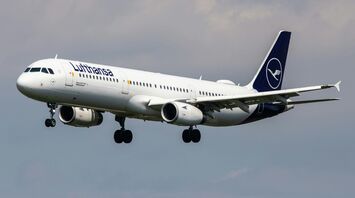 Lufthansa aircraft landing against a cloudy sky