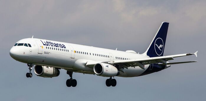 Lufthansa aircraft landing against a cloudy sky