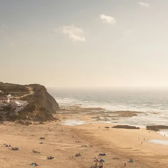 Monte Clérigo beach with cliffs, village houses and Atlantic waves