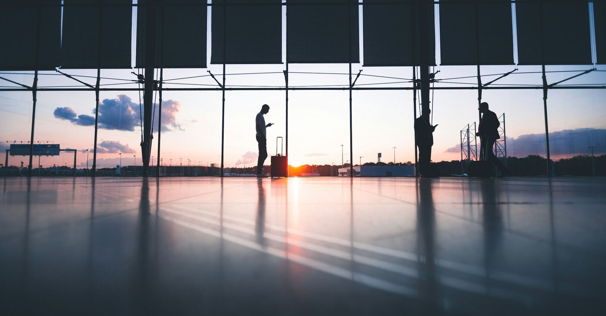 Passengers waiting inside an airport terminal at sunset