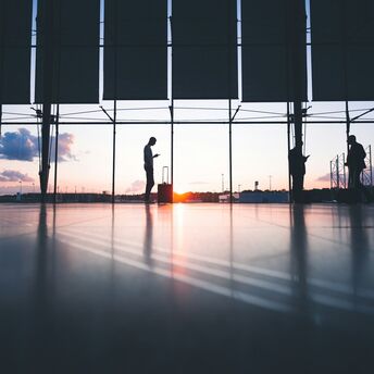 Passengers waiting inside an airport terminal at sunset