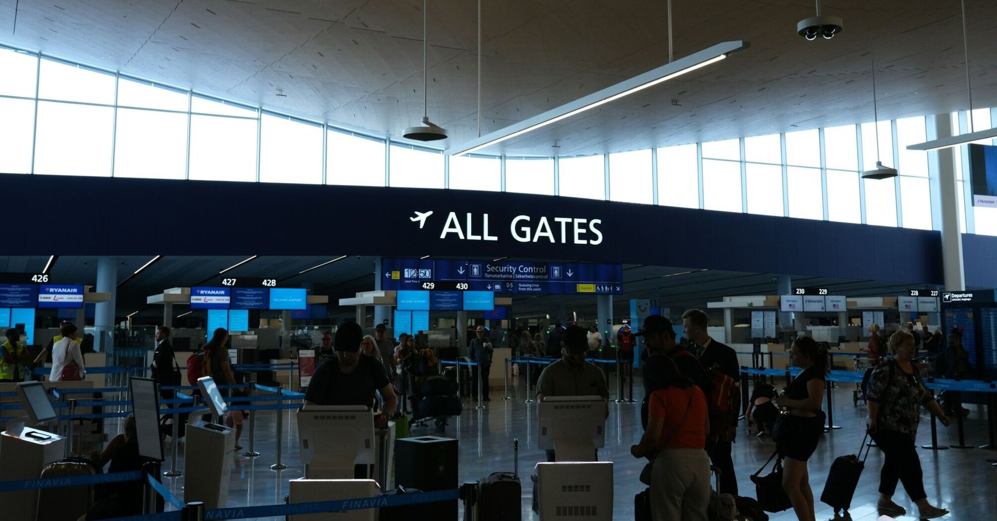 Passengers near all gates sign inside an airport terminal