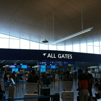 Passengers near all gates sign inside an airport terminal