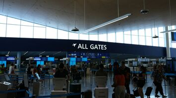 Passengers near all gates sign inside an airport terminal