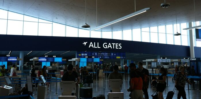 Passengers near all gates sign inside an airport terminal