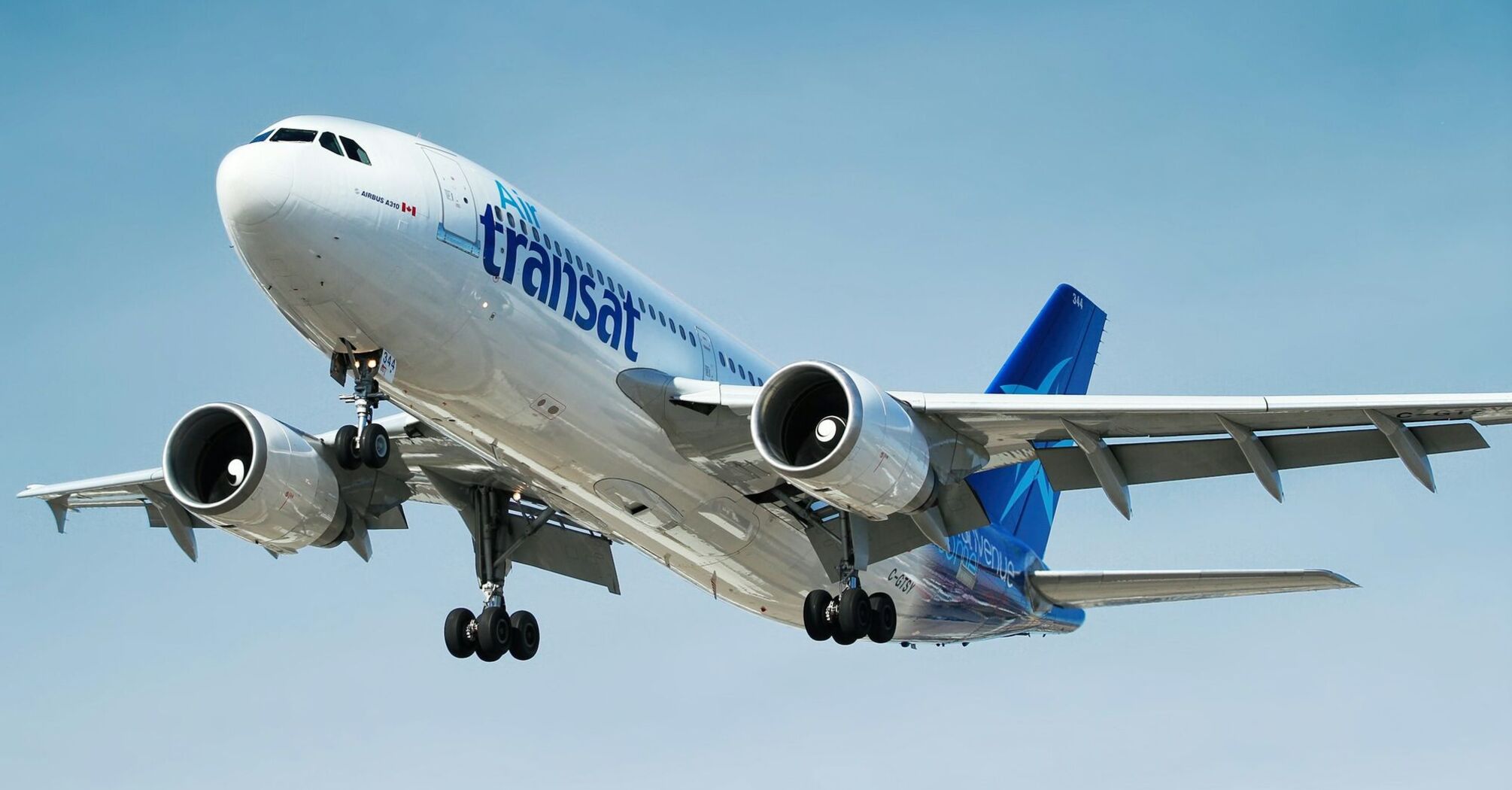 Air Transat aircraft landing against a blue sky