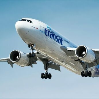 Air Transat aircraft landing against a blue sky