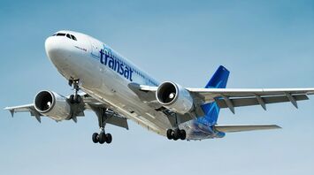Air Transat aircraft landing against a blue sky