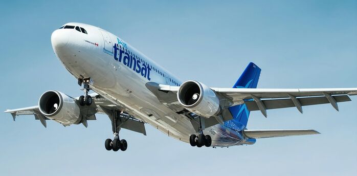 Air Transat aircraft landing against a blue sky