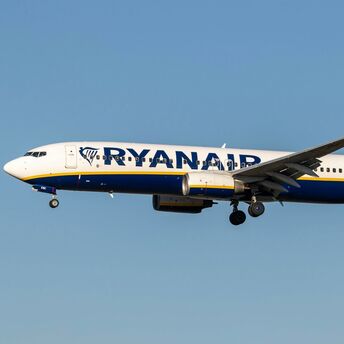 Ryanair aircraft flying against a clear blue sky