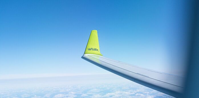 airBaltic aircraft wing seen above clouds during a flight