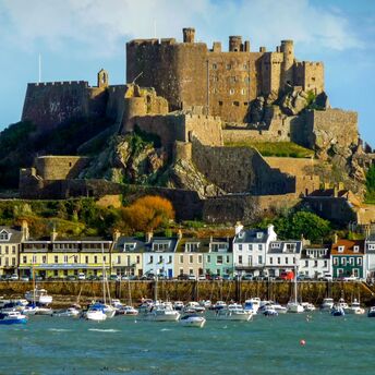 Jersey harbour with boats below a hilltop castle