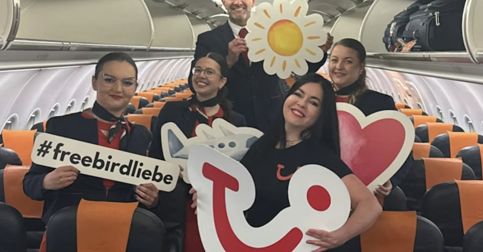 Flight crew posing inside a TUI-chartered aircraft cabin