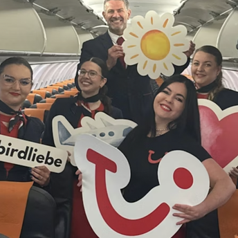 Flight crew posing inside a TUI-chartered aircraft cabin
