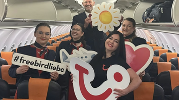 Flight crew posing inside a TUI-chartered aircraft cabin
