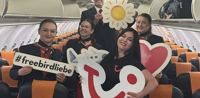 Flight crew posing inside a TUI-chartered aircraft cabin