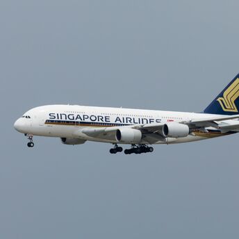 Singapore Airlines aircraft flying against a grey sky