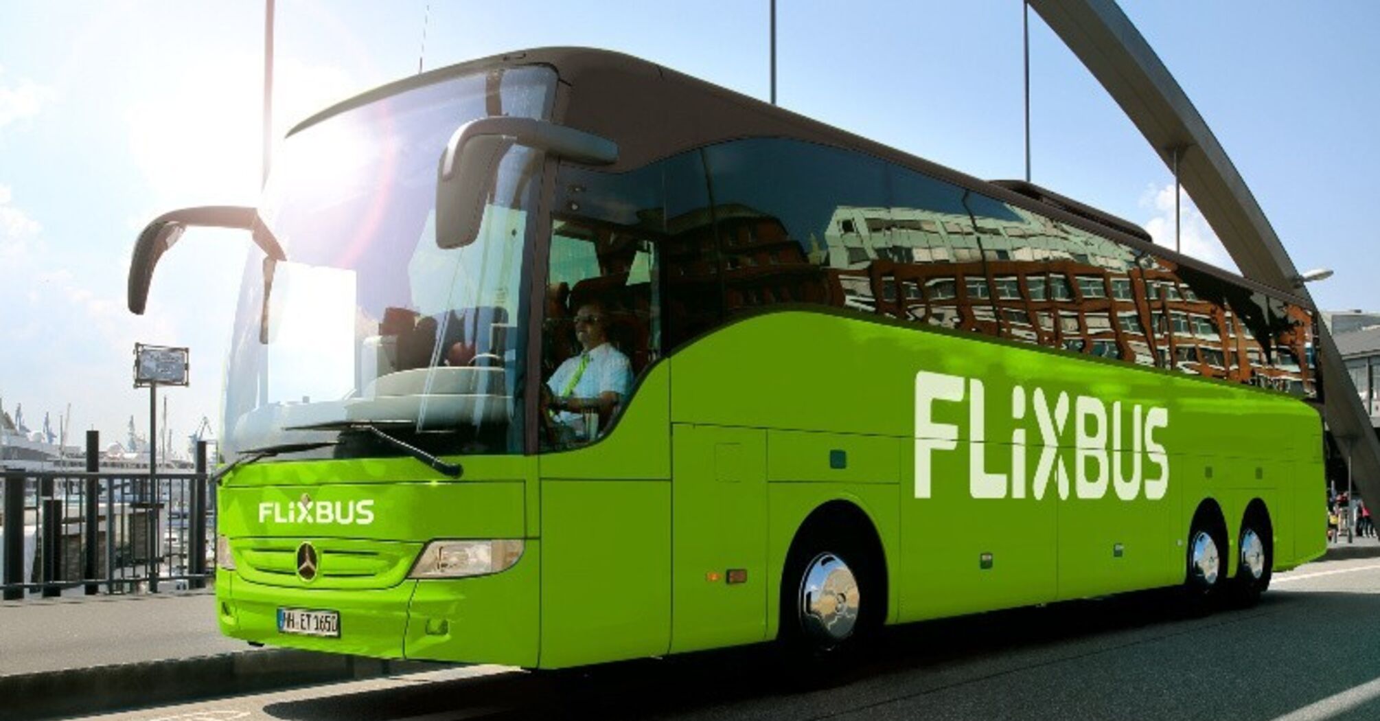 Green FlixBus coach parked near a waterfront terminal