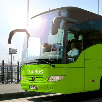 Green FlixBus coach parked near a waterfront terminal