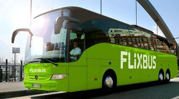 Green FlixBus coach parked near a waterfront terminal