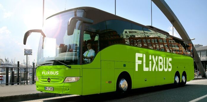 Green FlixBus coach parked near a waterfront terminal
