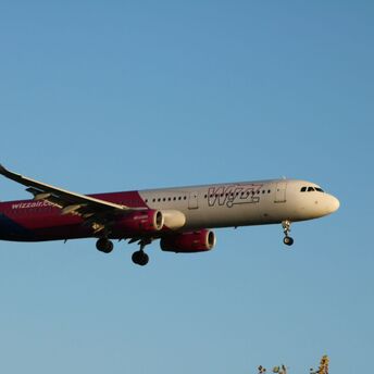 Wizz Air aircraft flying against a clear blue sky