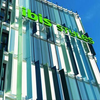 Exterior of the ibis Styles Munich Airport hotel with green signage