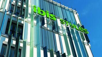 Exterior of the ibis Styles Munich Airport hotel with green signage