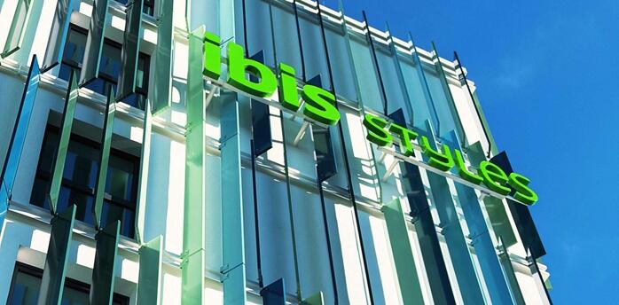 Exterior of the ibis Styles Munich Airport hotel with green signage