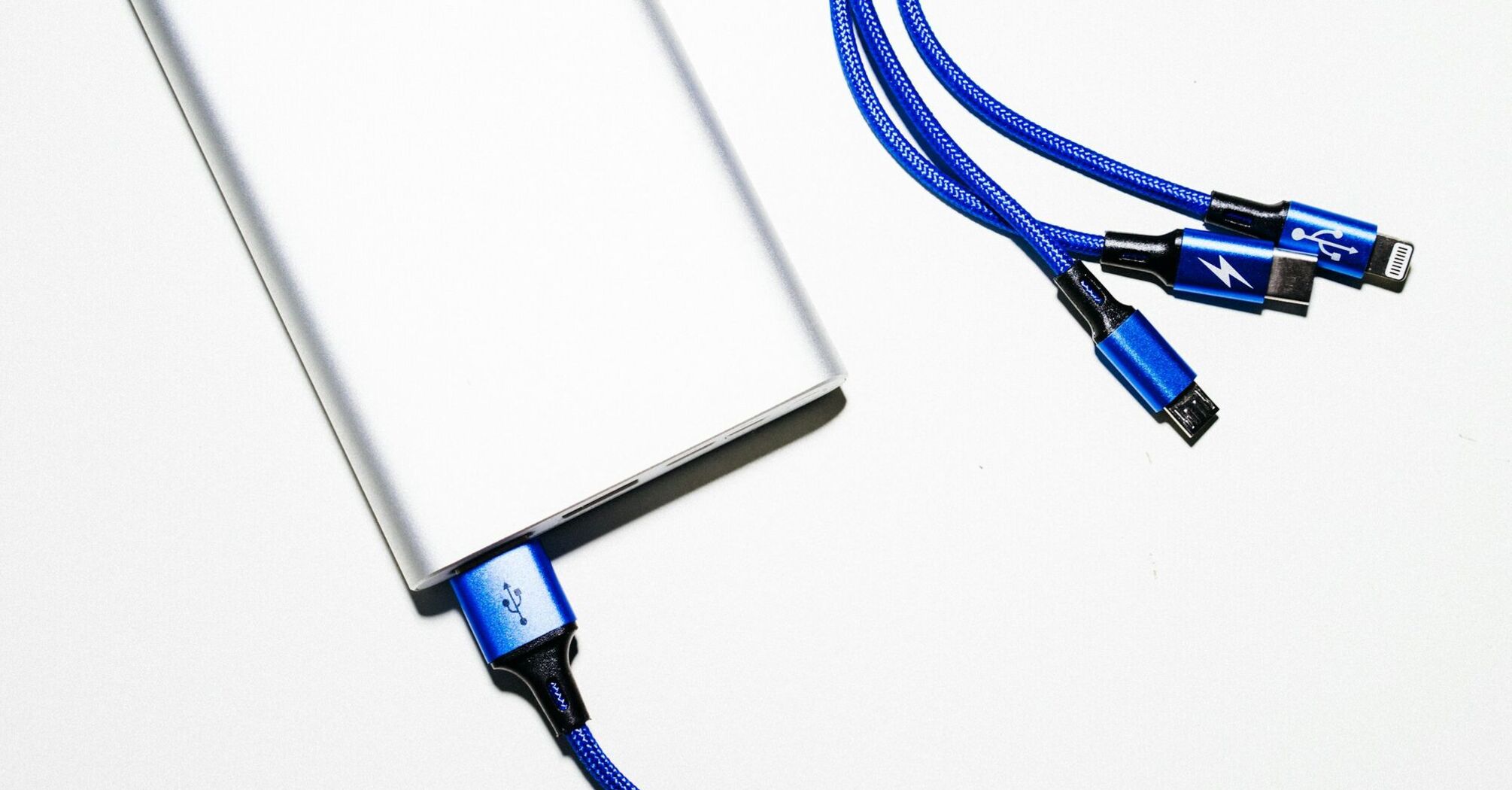 Portable power bank with multiple charging cables on a white background
