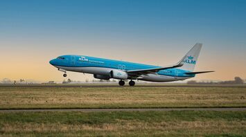 KLM aircraft taking off from a runway at sunset