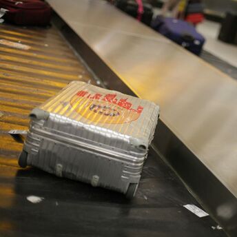 Silver suitcase on an airport baggage carousel