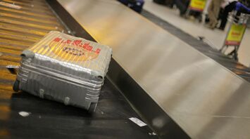 Silver suitcase on an airport baggage carousel