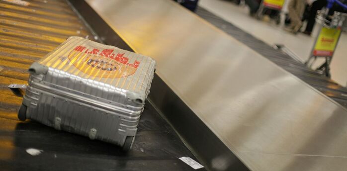 Silver suitcase on an airport baggage carousel