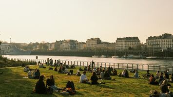 People sitting by the river in Nantes at sunset